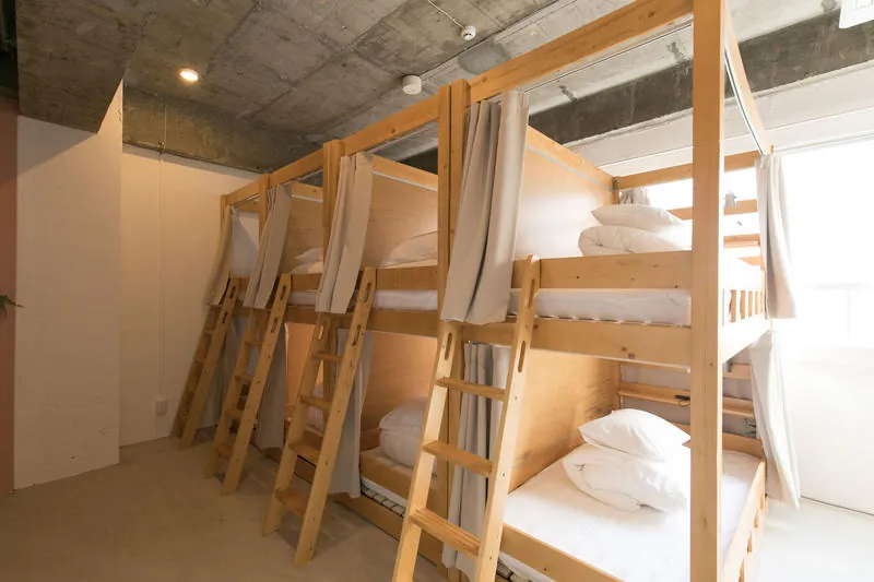 Dormitory with wooden bunk beds and curtains