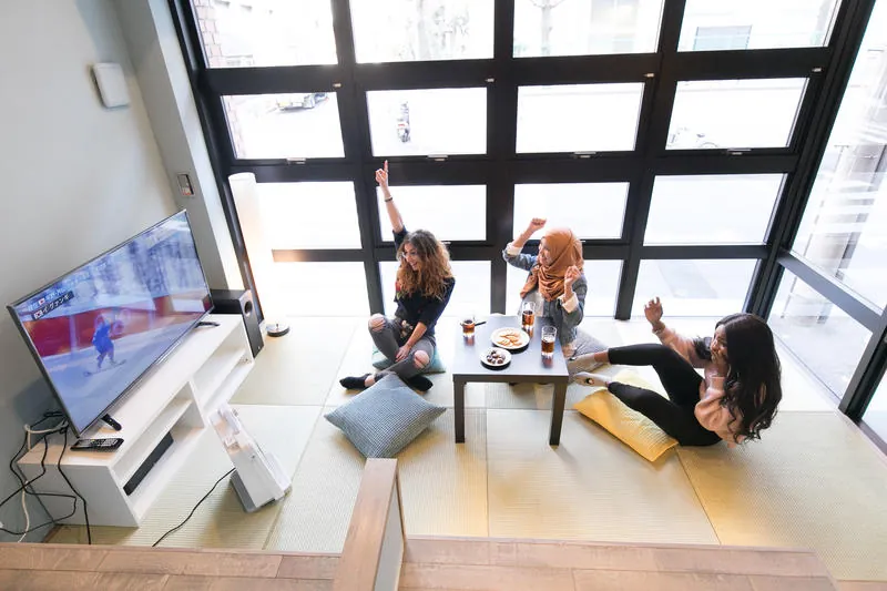 Guests sitting around a low table in the lounge beside a tall window