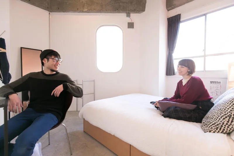 Two guests talking in a private room with a double bed
