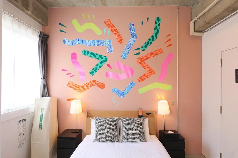 Private room with a double bed and a colourful painted wall