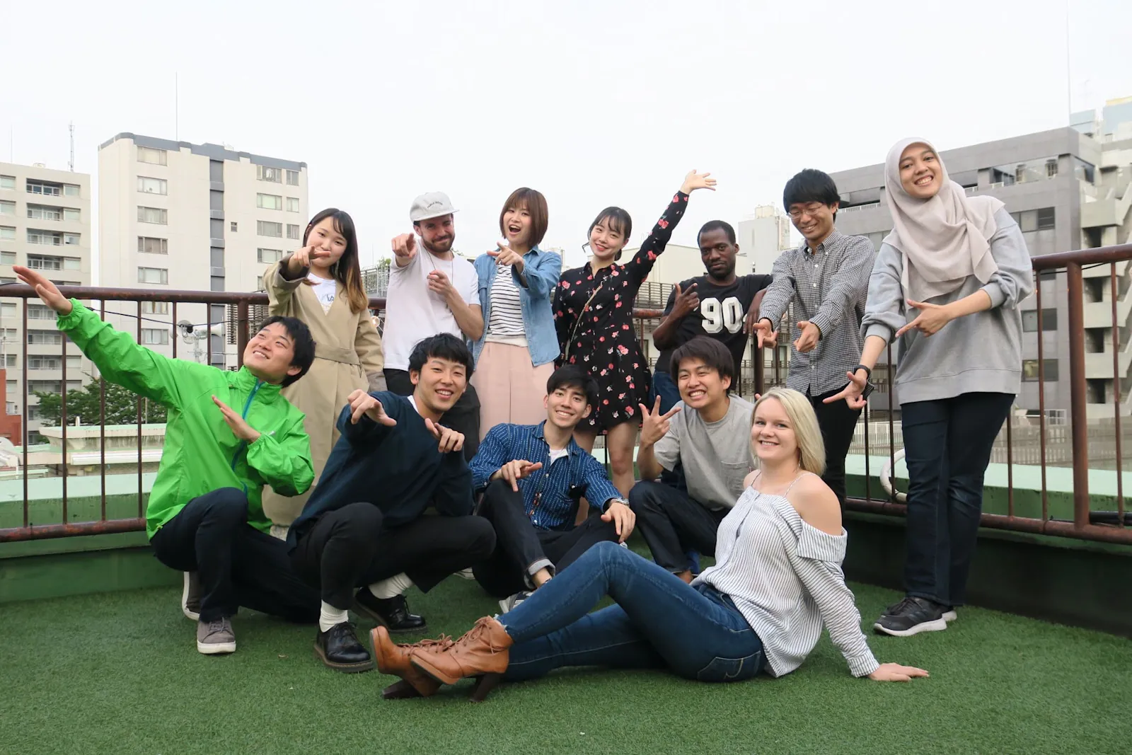 A group of guests and staff posing together on the rooftop lawn